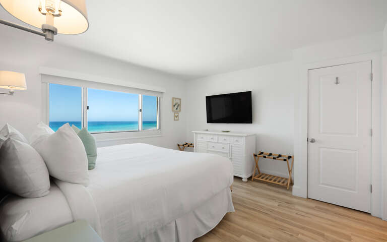 Wake up to breathtaking gulf views from your serene bedroom sanctuary, where white linens and coastal breezes create the perfect retreat.