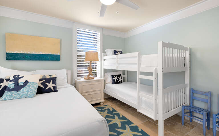 Your family bedroom features nautical-themed dÃ©cor with bunk beds for the kids and comfortable seating.