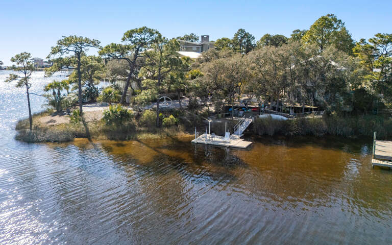 Waterfront property with private dock nestled among mature trees along peaceful lake waters.