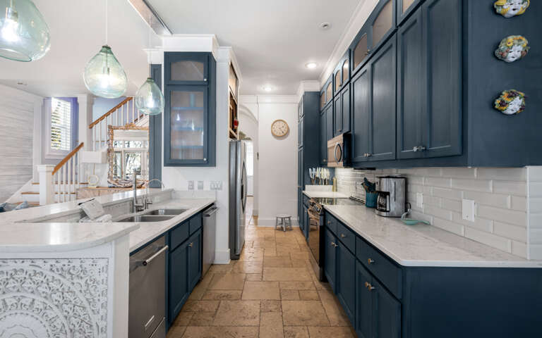 Your spacious galley kitchen features rich navy cabinets, marble countertops, and stainless appliancesâperfect for preparing memorable meals together.