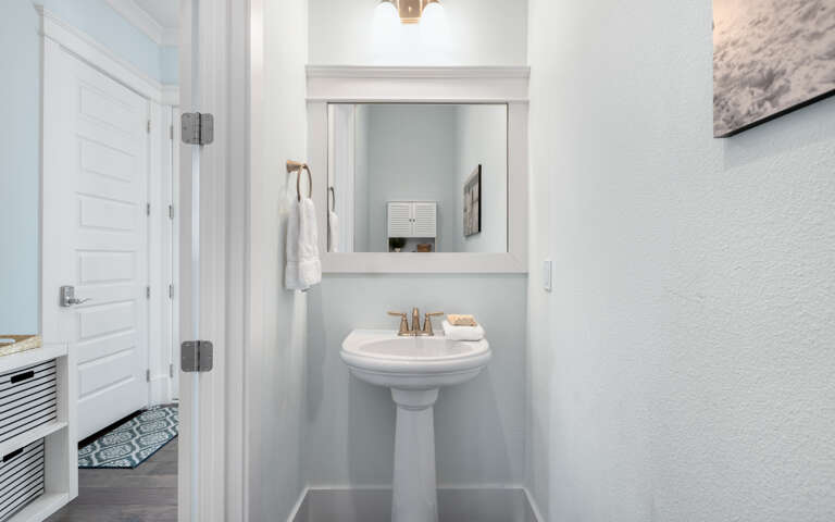 Step into your pristine powder room featuring elegant fixtures and thoughtful touches for your convenience.