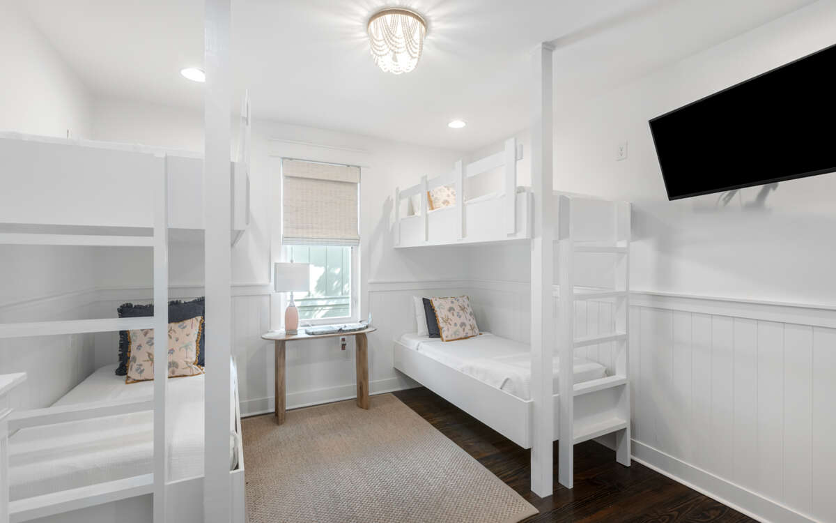 Interior Of A Room With White Bunk Beds And A Television