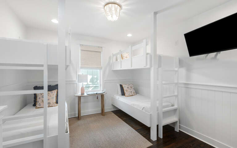 Interior Of A Room With White Bunk Beds And A Television
