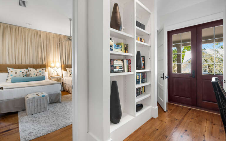 Step into your cozy bedroom featuring built-in bookshelves filled with reads for quiet evenings and warm hardwood floors throughout.