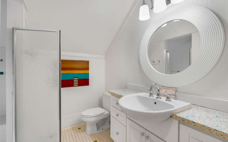 Step into your bright, modern bathroom with a sleek vessel sink and unique circular mirror that adds elegant style to your daily routine.