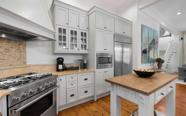 Your dream kitchen awaits with warm wood countertops, professional-grade appliances, and charming white cabinetry perfect for creating memorable meals.