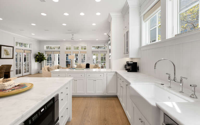 Your bright, elegant kitchen flows seamlessly into the living space, featuring pristine white cabinetry and expansive countertops perfect for cooking adventures.