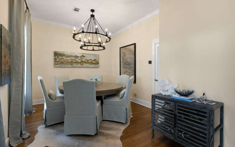 Gather around your elegant dining table beneath the stunning chandelier for memorable meals together.