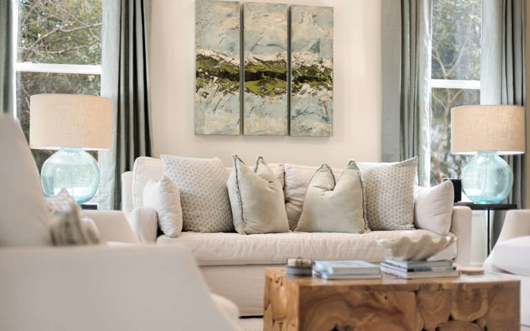 Sink into plush cushions in your serene living space, where soft blues and natural light create the perfect retreat for relaxation.