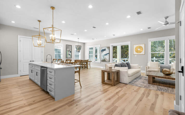 Your open-concept kitchen and living space invites you to cook, dine, and relax in style with warm wood tones and elegant lighting.