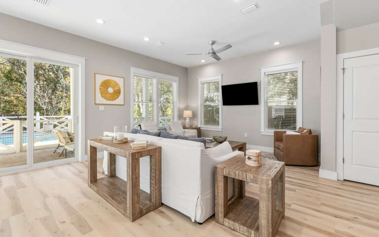 Relax in your bright living room with comfortable seating and pool views through sliding doors.