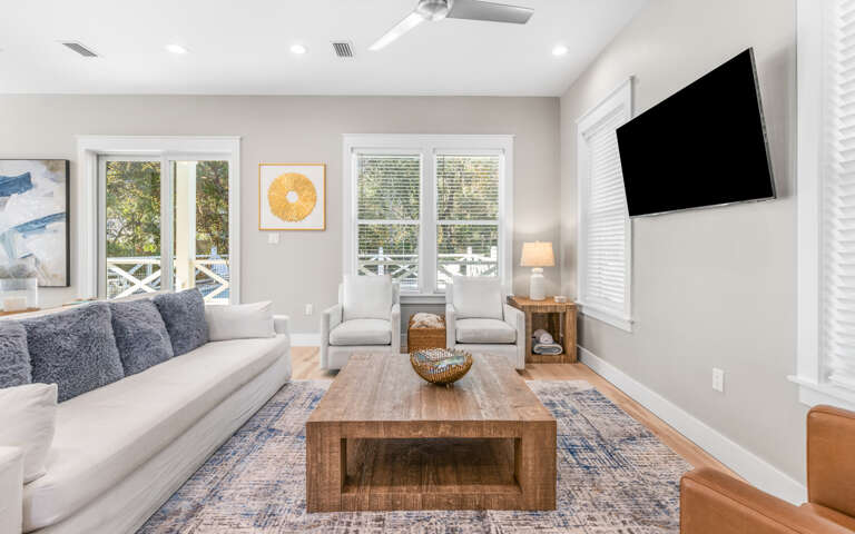 Sink into plush seating in your bright living room, where natural light streams through French doors and cozy textures invite relaxation.