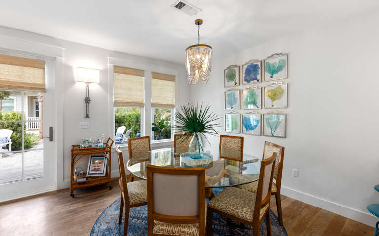 Bright Dining Room With Glass Table And Artwork On The Wall