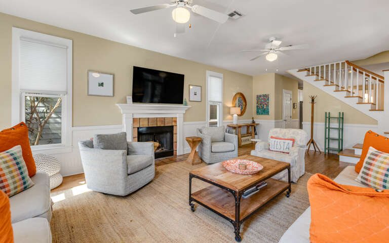 Gather around your cozy fireplace in this bright living space, where comfortable seating and warm touches create the perfect spot for relaxation.