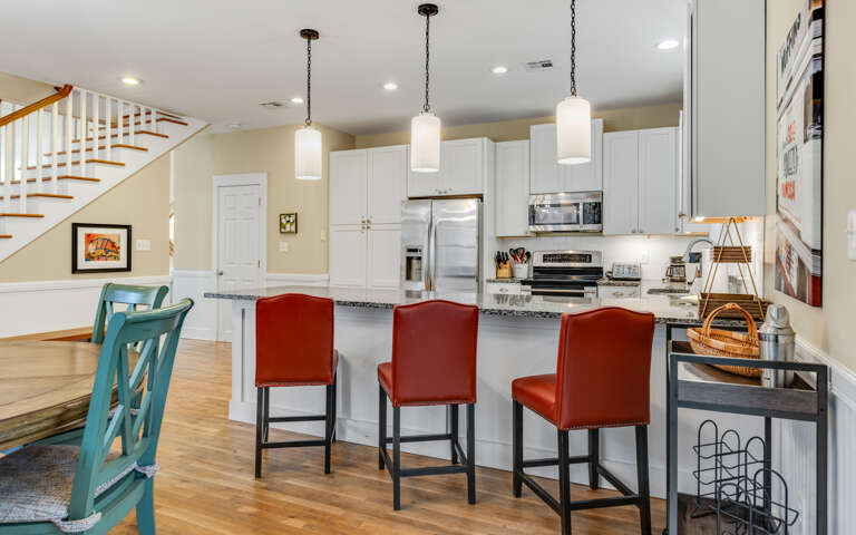 Gather around the spacious kitchen island where meals become memories, featuring gleaming granite counters and stylish pendant lighting for your culinary adventures.