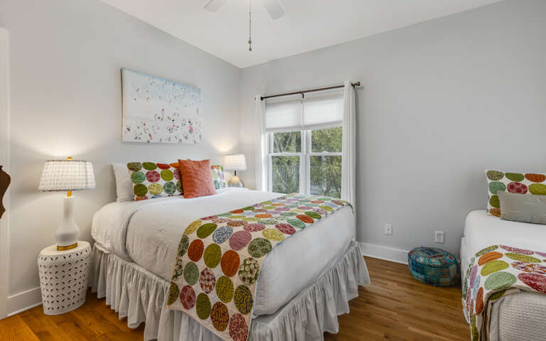 Unwind in your cheerful bedroom featuring colorful linens, natural light, and thoughtful touches that make every night's rest feel special.