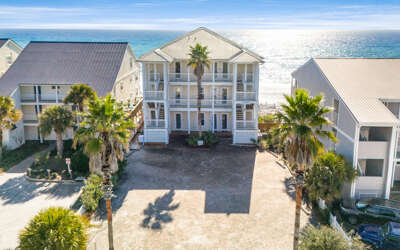 Beachfront property with palm trees and direct beach access in a tropical coastal setting.