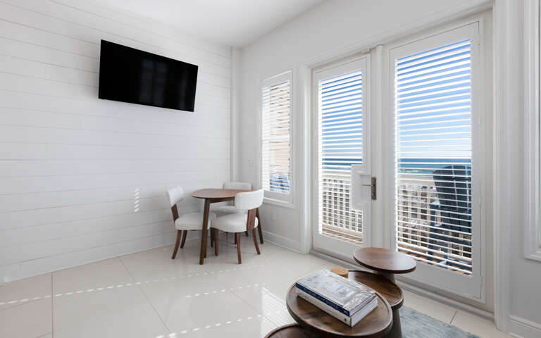 Bright coastal living space with sea views through French doors and your own dining table for morning coffee.
