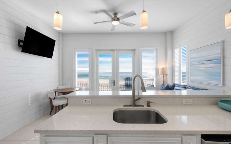 Your bright kitchen features sleek countertops and stunning ocean views through expansive windows, perfect for morning coffee with sea breezes.
