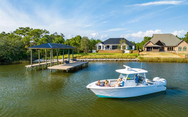Boat On Water Near Residential Buildings With Dock