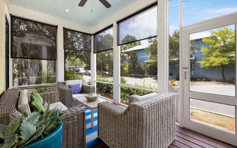 Bright, Breezy Porch With Wicker Furniture Overlooking Lush Garden