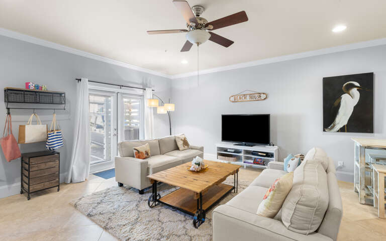 Light-filled Living Space With Sofas, Coffee Table, And Ceiling Fan