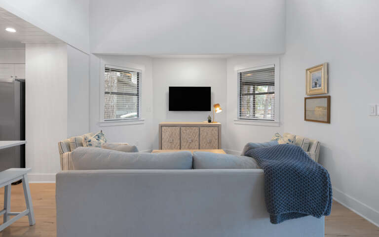 Relax in your stylish living room with plush seating, modern entertainment, and natural light streaming through windows.