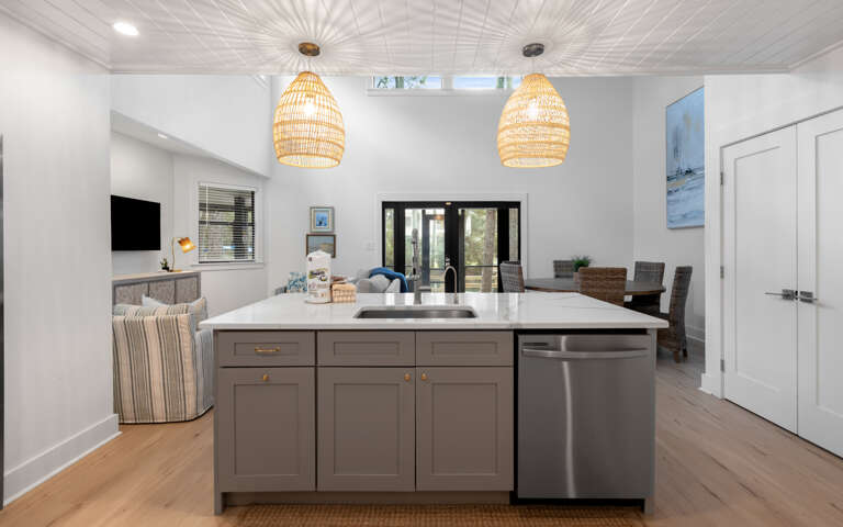 Your open-plan kitchen flows into a welcoming living space, where modern fixtures and warm wood tones create the perfect gathering spot.