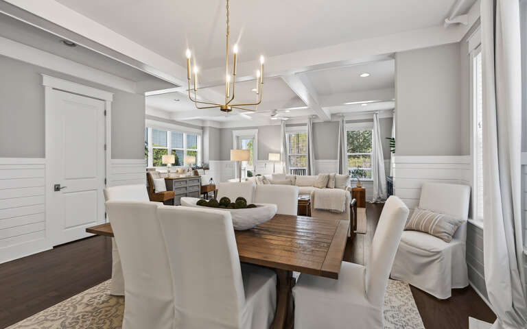 Gather around your elegant dining table where natural light streams through pristine windows, creating the perfect setting for memorable meals together.