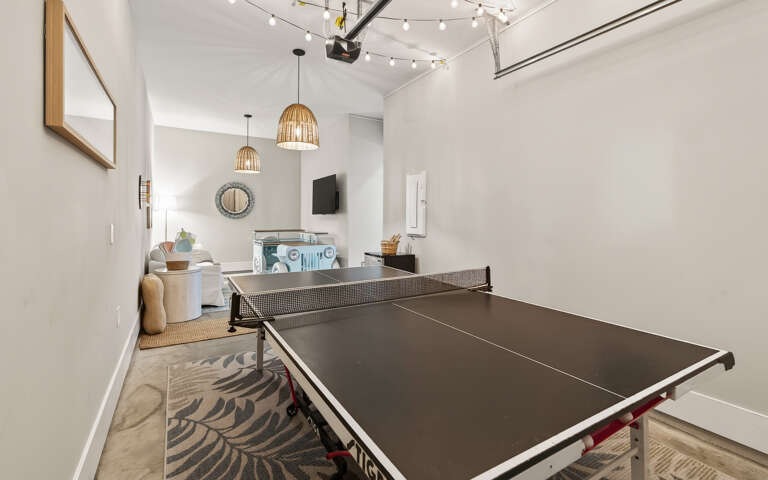 Challenge friends to ping pong in your stylish game room, complete with wicker pendant lights and cozy seating nearby.