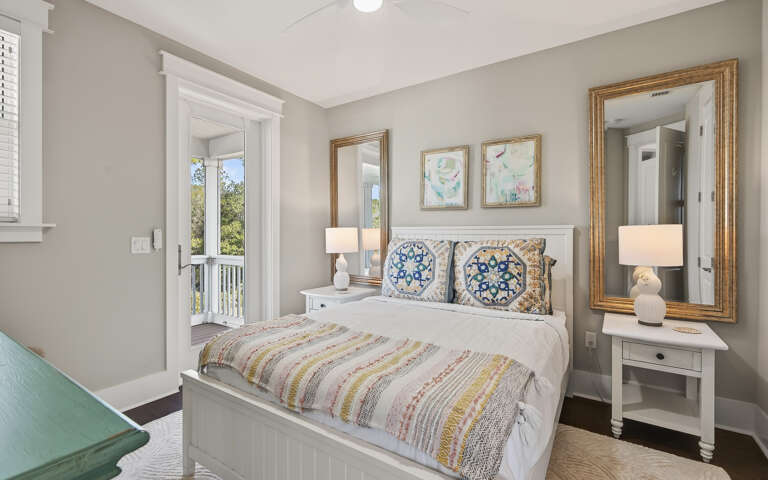 Unwind in your peaceful bedroom sanctuary with soft linens, elegant gold mirrors, and serene balcony views of the lush landscape.