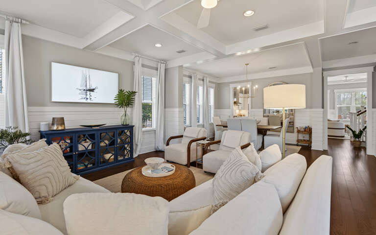 Unwind in your elegant living space with plush seating, coffered ceilings, and coastal charm that creates the perfect retreat.