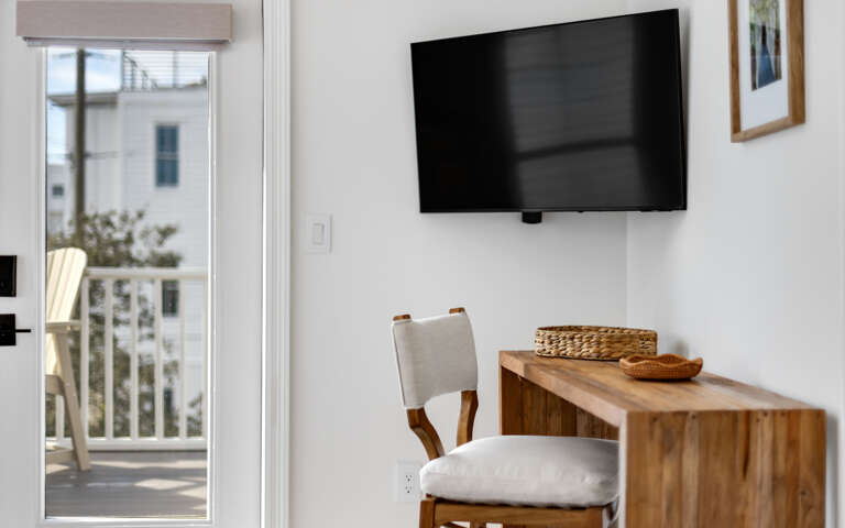 Relax in this bright living space with modern TV and warm wood accents, plus your own private balcony for morning coffee.