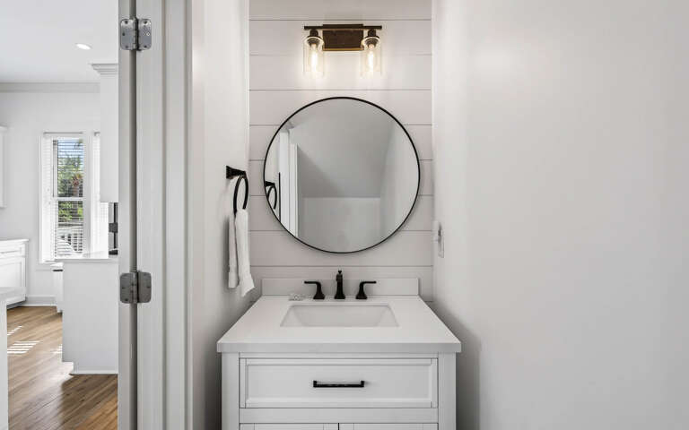 Step into your stylish bathroom featuring a sleek round mirror, elegant vanity, and modern fixtures that create the perfect morning routine space.