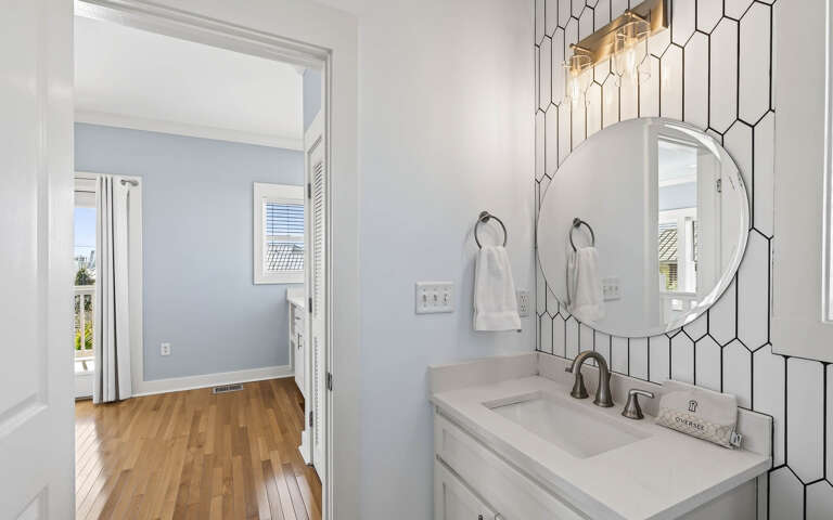 Fresh geometric tile adds modern style to your bathroom vanity, while natural light from connecting rooms creates a bright, welcoming space.