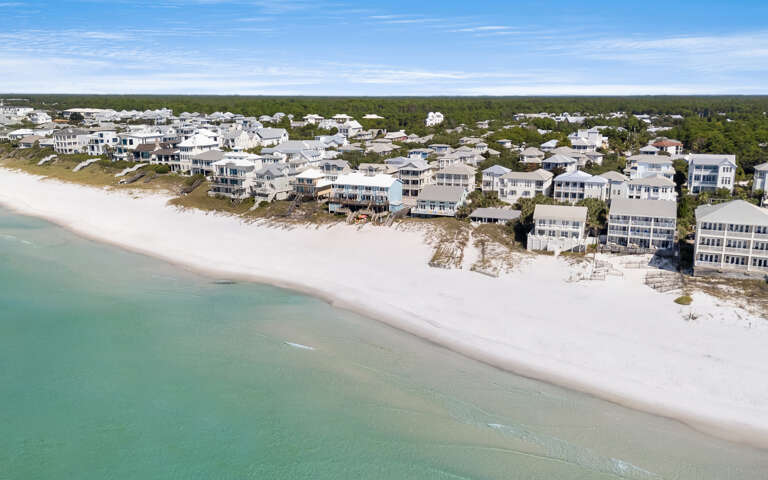 Stunning beachfront community with pristine white sand beaches and crystal-clear turquoise waters along the coastline.