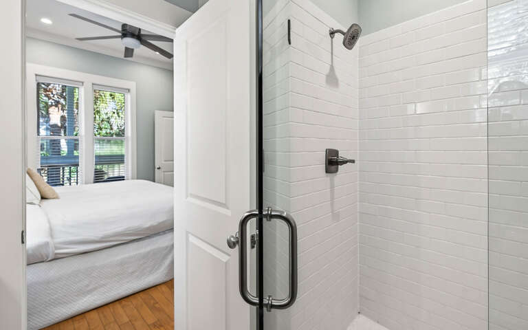 Unwind in your elegant ensuite with a sleek glass shower featuring white subway tiles and modern fixtures.