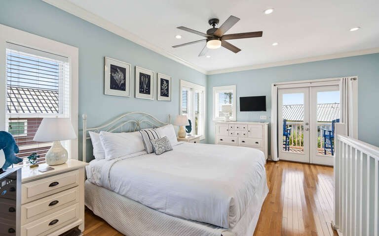 Wake up in your serene coastal bedroom with crisp white linens and ocean breezes flowing through your private balcony doors.