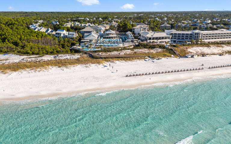 Beachfront Buildings Beside Blue Waters, White Sands With Loungers