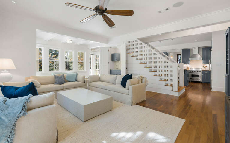 Bright, Spacious Living Room With Large Windows And Staircase