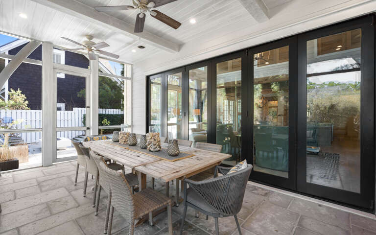 Your private covered patio awaits with rustic dining for eight, ceiling fans for comfort, and seamless indoor-outdoor flow through sliding glass doors.