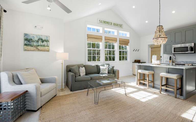 Sink into plush sofas in your bright, airy living space where natural light streams through charming windows, creating the perfect spot to unwind.