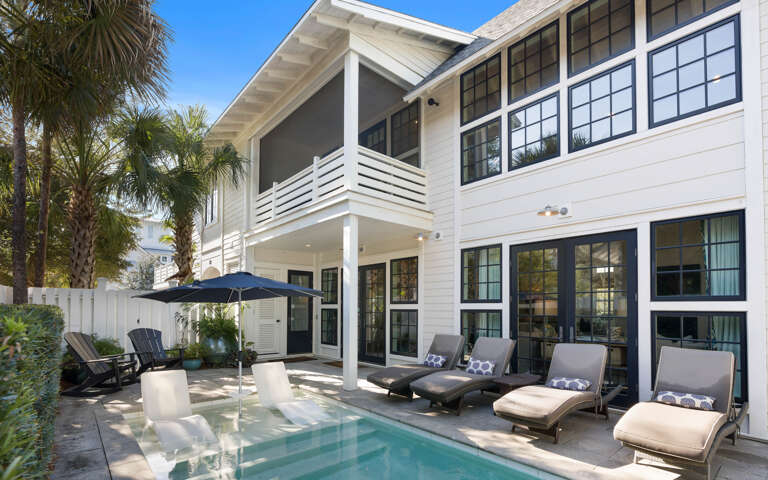 Your private oasis awaits with a sparkling pool, comfortable loungers, and tropical palms creating the perfect sunny retreat.