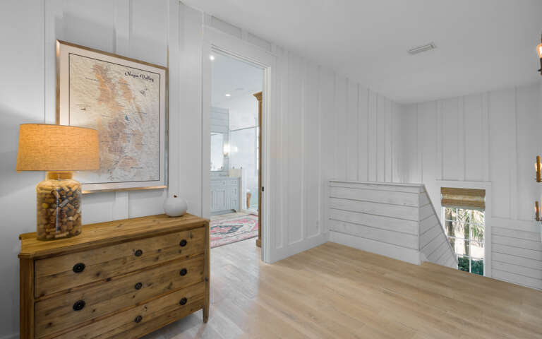 Your coastal-inspired hallway features warm wood accents and charming nautical touches, creating a welcoming transition between spaces.