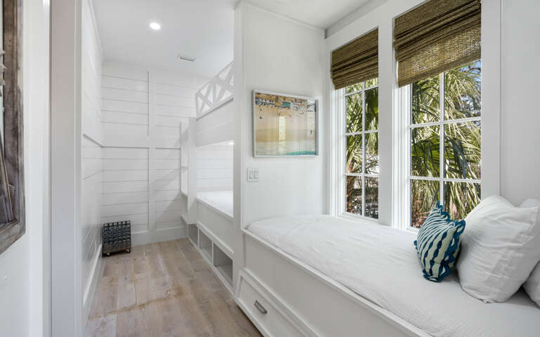 Cozy built-in bunk beds create your perfect hideaway, with tropical palm views through large windows and thoughtful storage beneath.