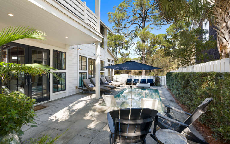 Unwind in your private backyard paradise with a sparkling pool, shaded dining, and lush tropical landscaping surrounding your modern retreat.