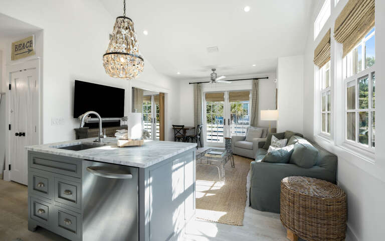 Your bright, airy living space features elegant coastal design with a stunning chandelier and seamless kitchen-to-living flow for perfect entertaining.