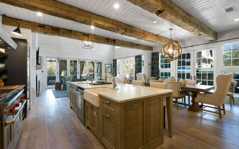 Your dream kitchen awaits with rustic wood beams, gleaming countertops, and a cozy dining nook bathed in natural light.