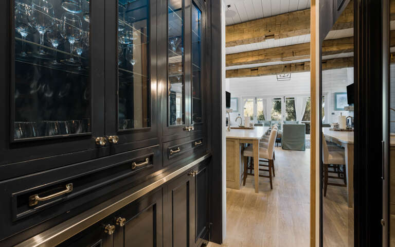 Your elegant bar area flows seamlessly into the open kitchen, where rich wood beams frame bright spaces perfect for entertaining.