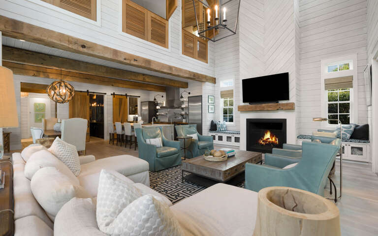 Relax in your spacious living room with soaring ceilings, exposed beams, and a crackling fireplace creating the perfect atmosphere for memorable evenings together.